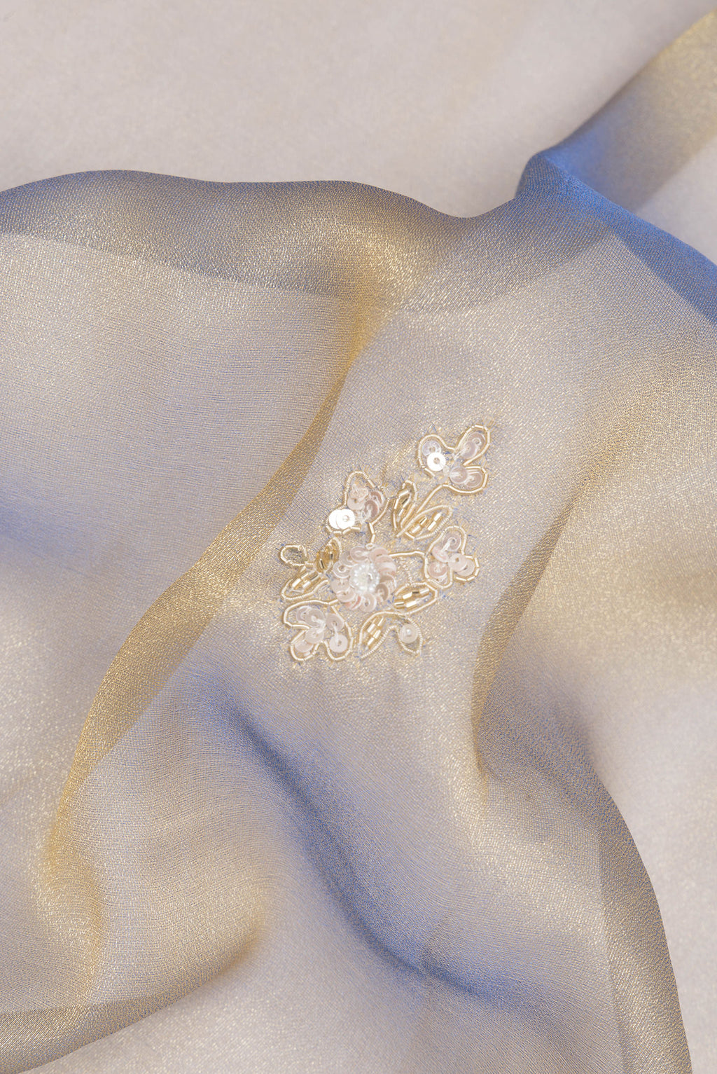 Close up of Light Blue Dual Tone Organza Saree with Embroidery on the body and Sequin Border.  displaying folds
