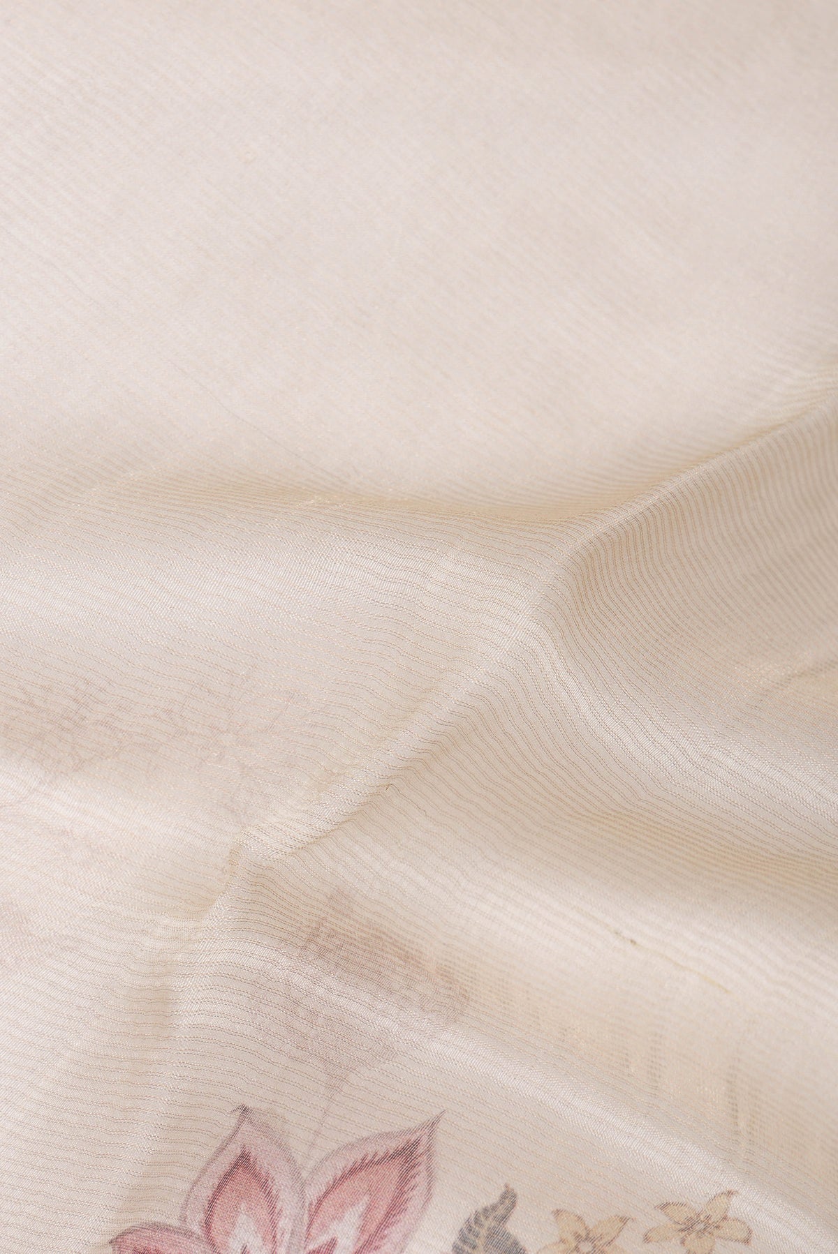 Close up of Cream Organza Saree with Floral Print on the body and Sequin Border.  displaying folds