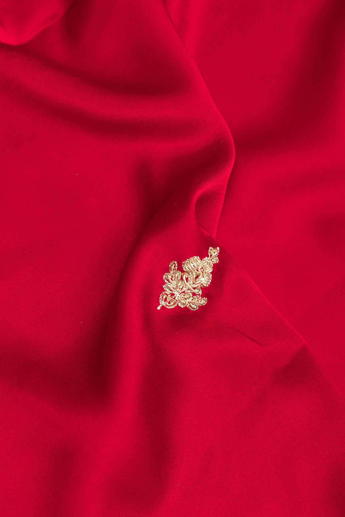Close up of Red Satin Saree with Embroidered on the body and Sequin Border.  displaying folds