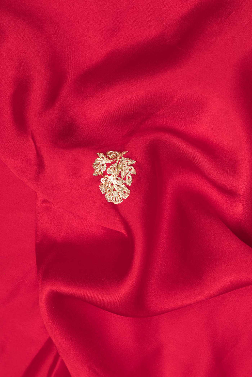Close up of Red Satin Saree with Embroidered on the body and Sequin Border.  displaying folds