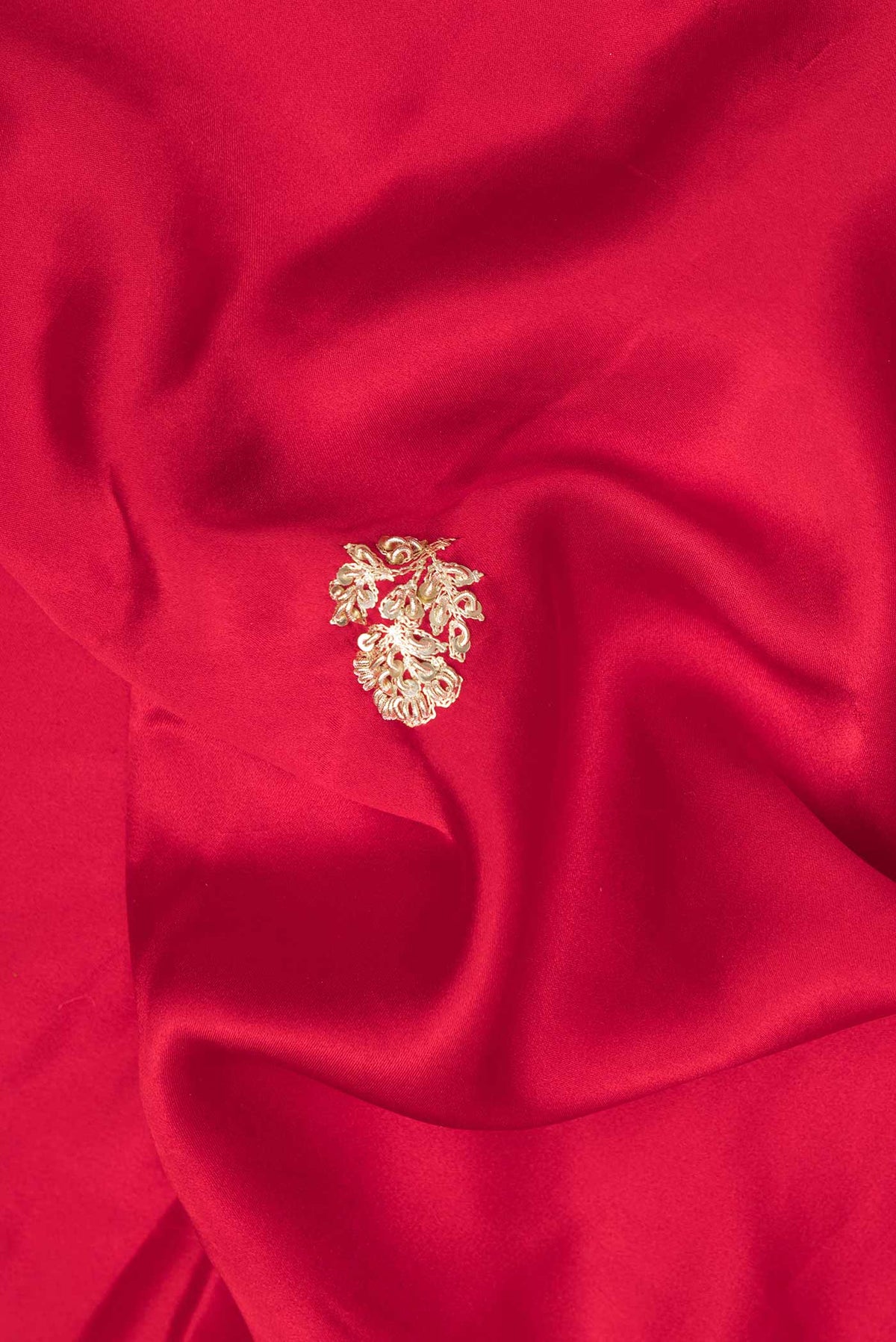Close up of Red Satin Saree with Embroidered on the body and Sequin Border.  displaying folds