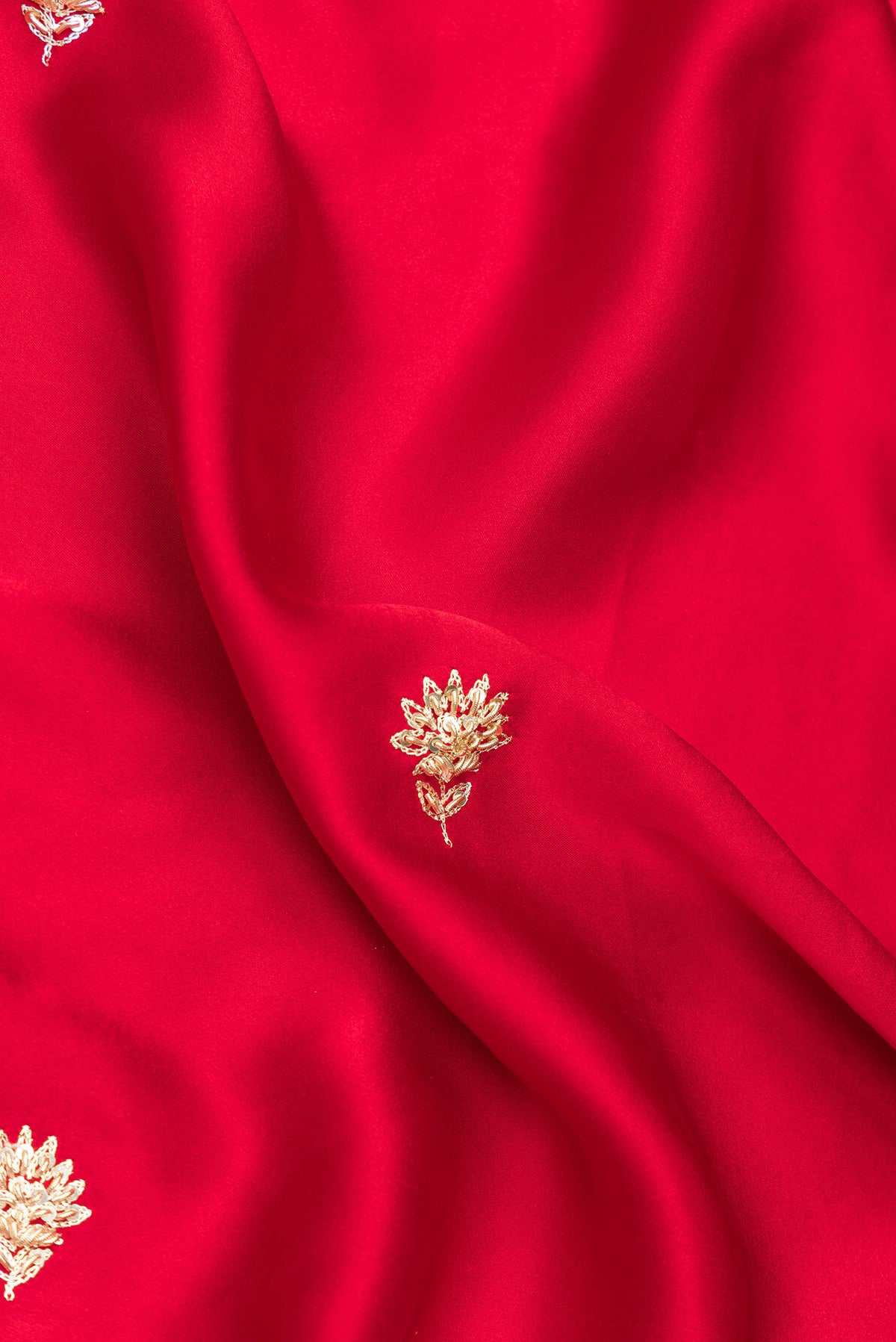 Close up of Red Satin Saree with Embroidered on the body and Sequin Border.  displaying folds