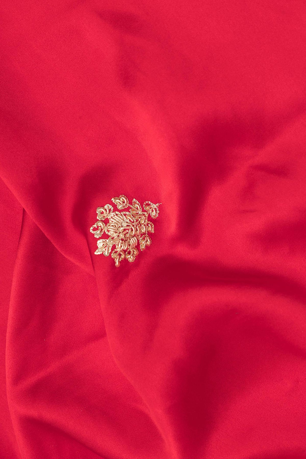 Close up of Red Satin Saree with Embroidered on the body and Sequin Border.  displaying folds