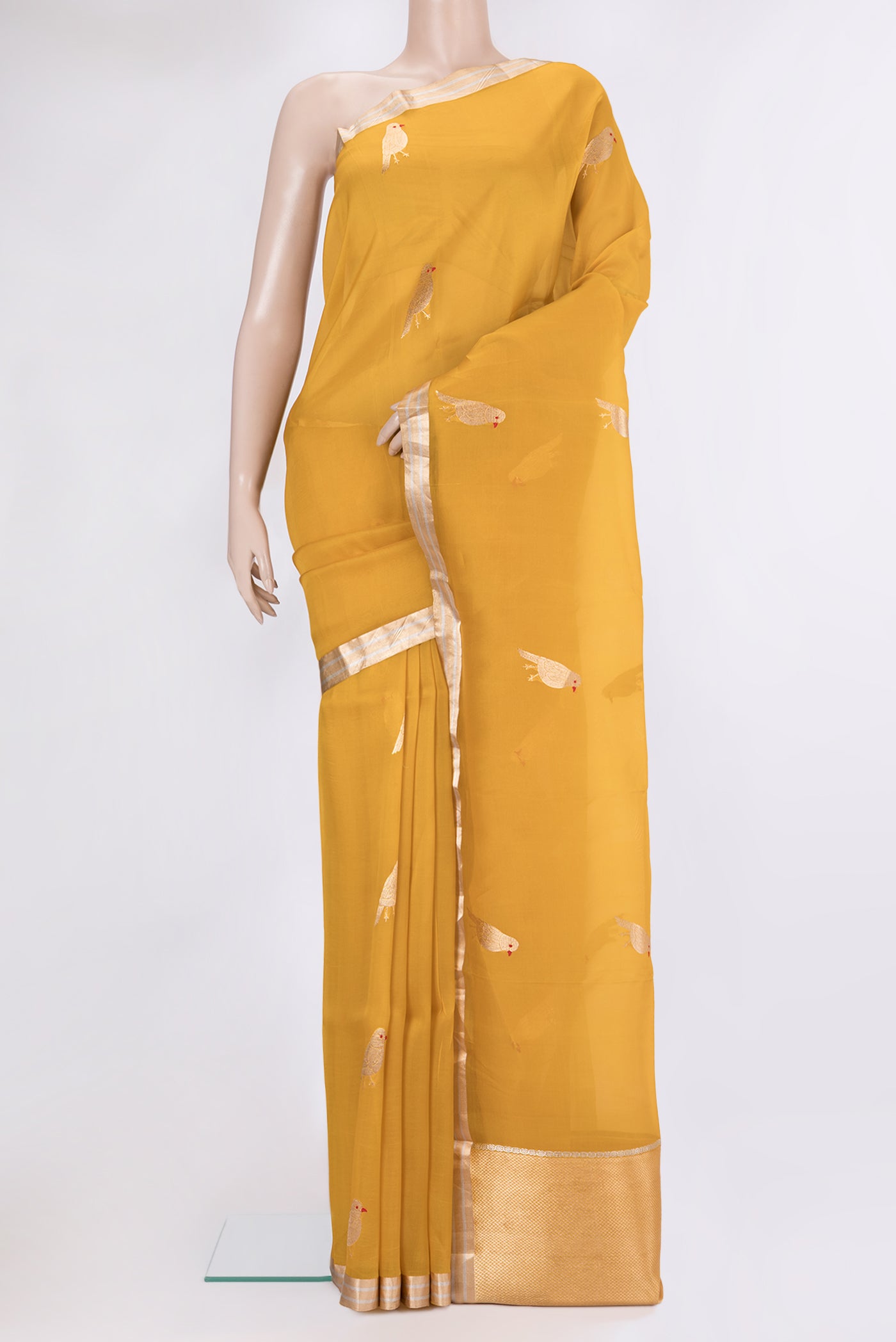 Yellow Organza Silk Saree with Zari Butta on the body and Zari Border.  displayed on a mannequin