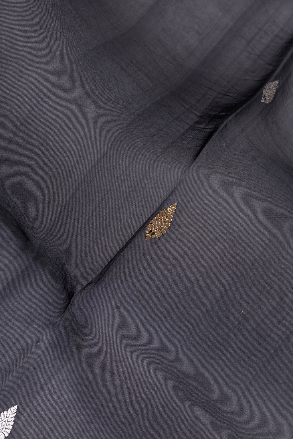 Close up of Navy Blue Organza Silk Saree with Zari Butta on the body and Fancy Border.  displaying folds