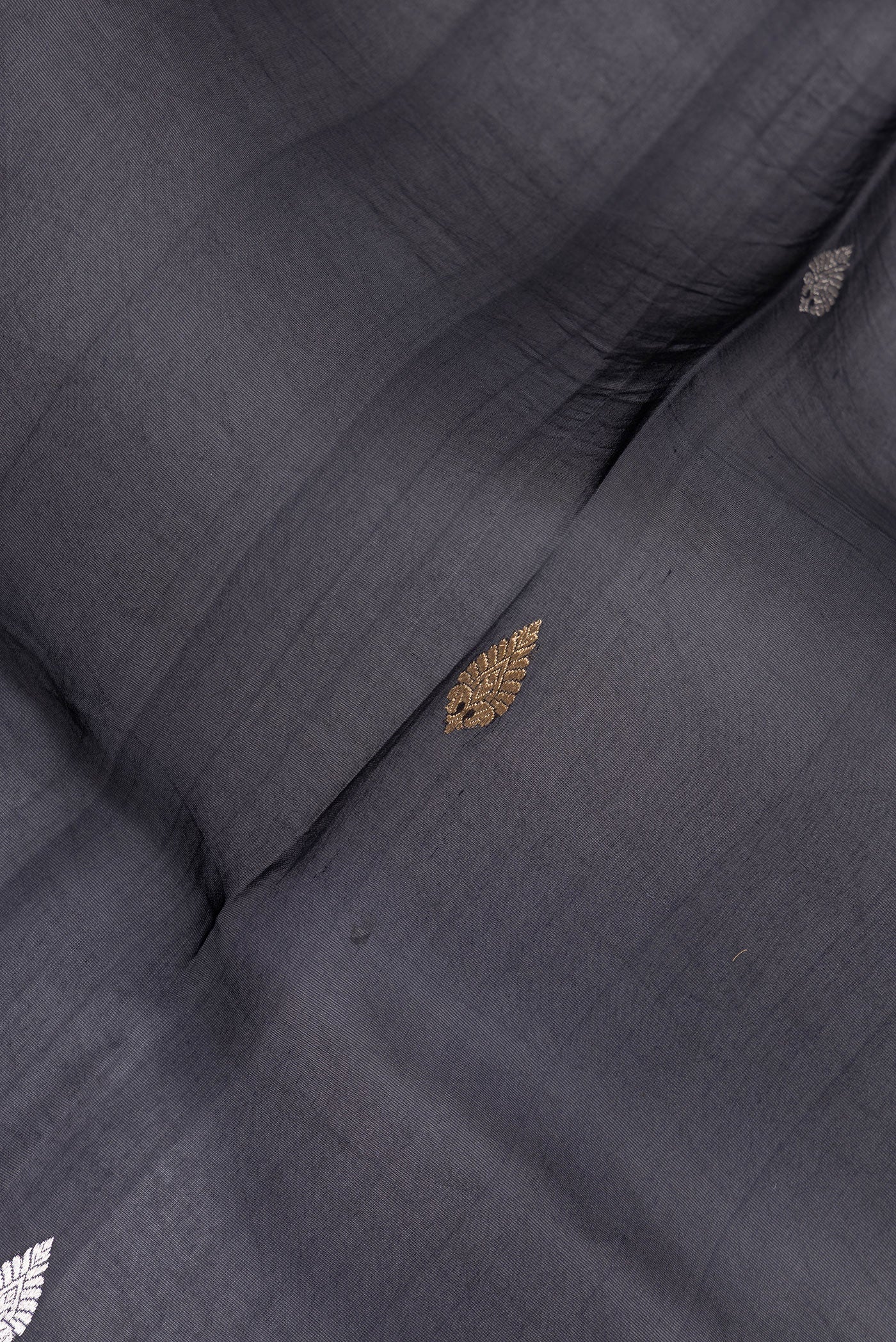 Close up of Navy Blue Organza Silk Saree with Zari Butta on the body and Fancy Border.  displaying folds
