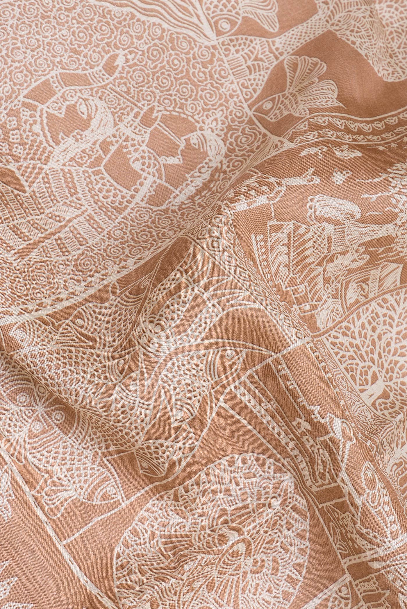 Close up of Golden Peach Tussar Silk Saree with Printed design on the body and Fancy Border.  displaying folds