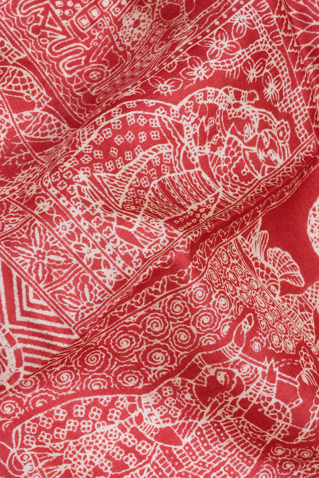 Close up of Red Tussar Silk Saree with Printed design on the body and Fancy Border.  displaying folds