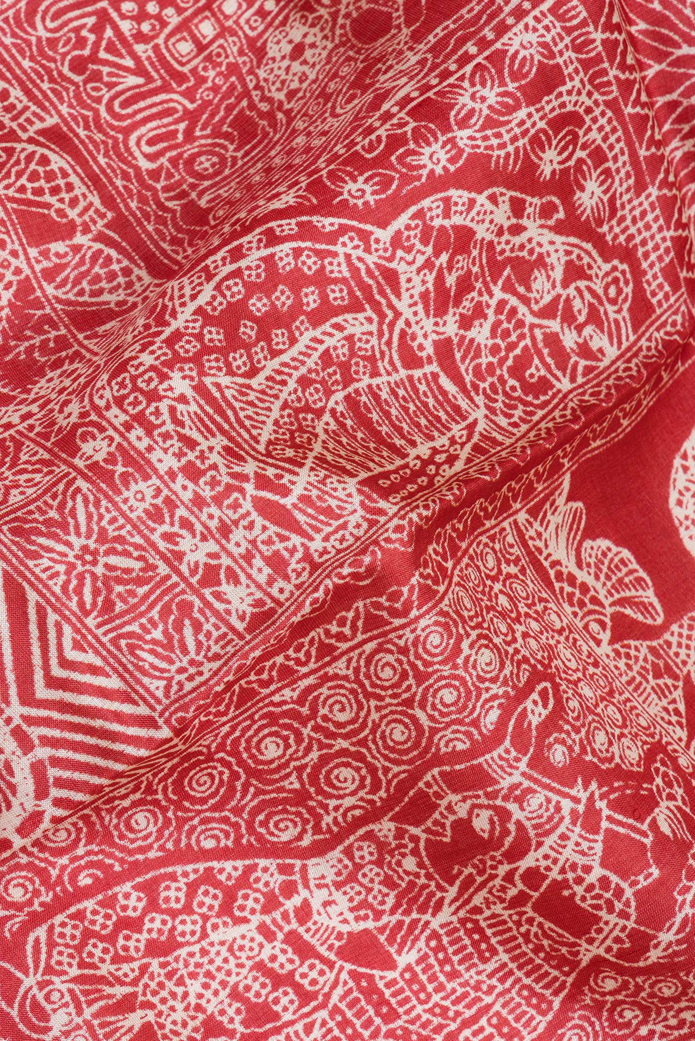 Close up of Red Tussar Silk Saree with Printed design on the body and Fancy Border.  displaying folds