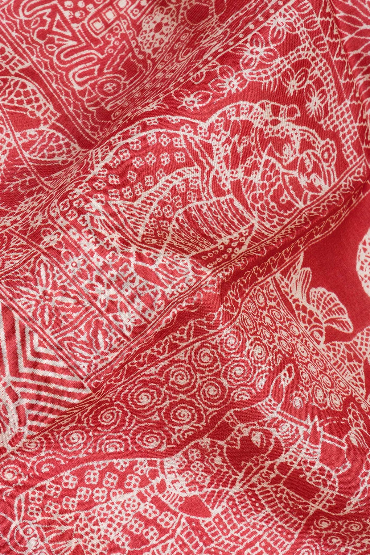 Close up of Red Tussar Silk Saree with Printed design on the body and Fancy Border.  displaying folds