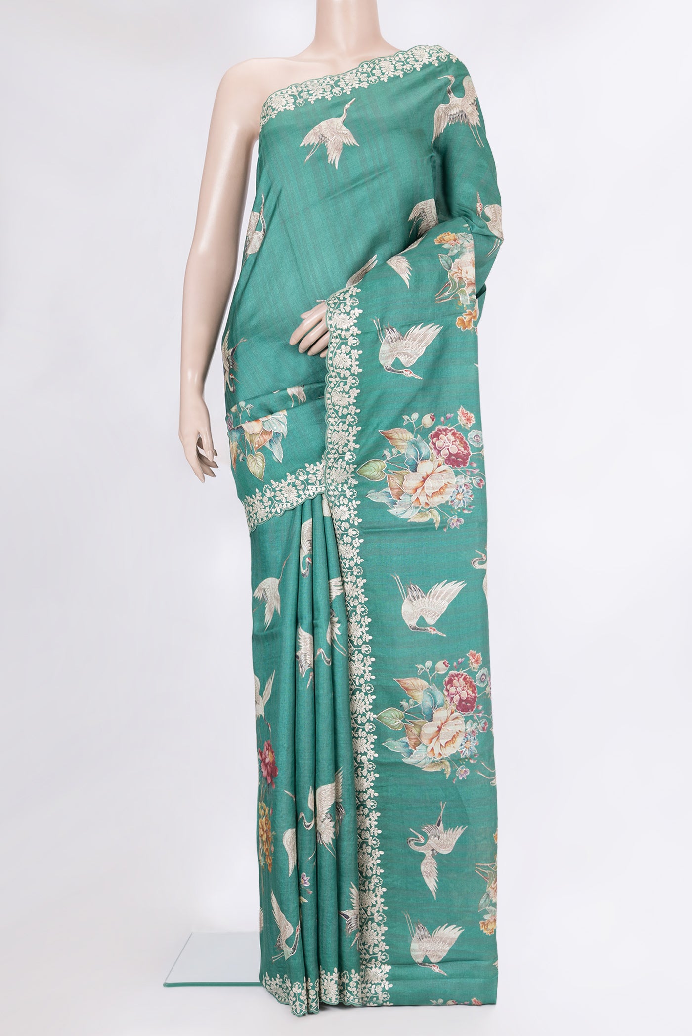 Green Tussar Silk Saree with Embroidery on the body and Embroidery Border.  displayed on a mannequin
