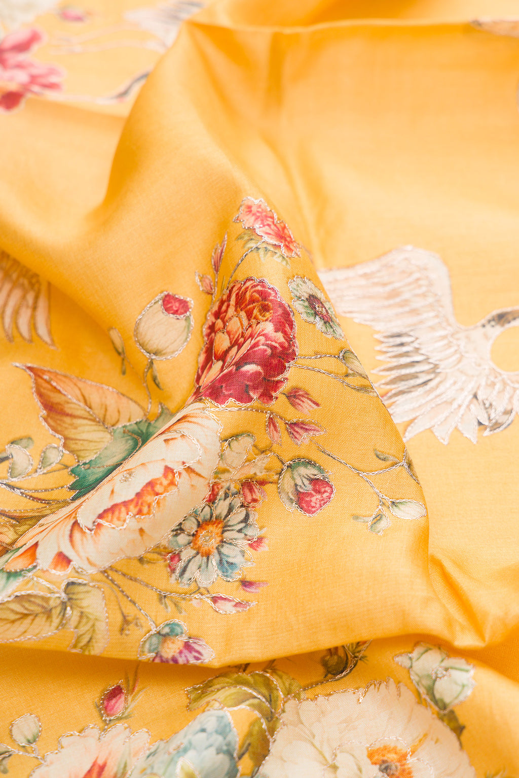 Close up of Yellow Tussar Silk Saree with Embroidery on the body and Fancy Border.  displaying folds