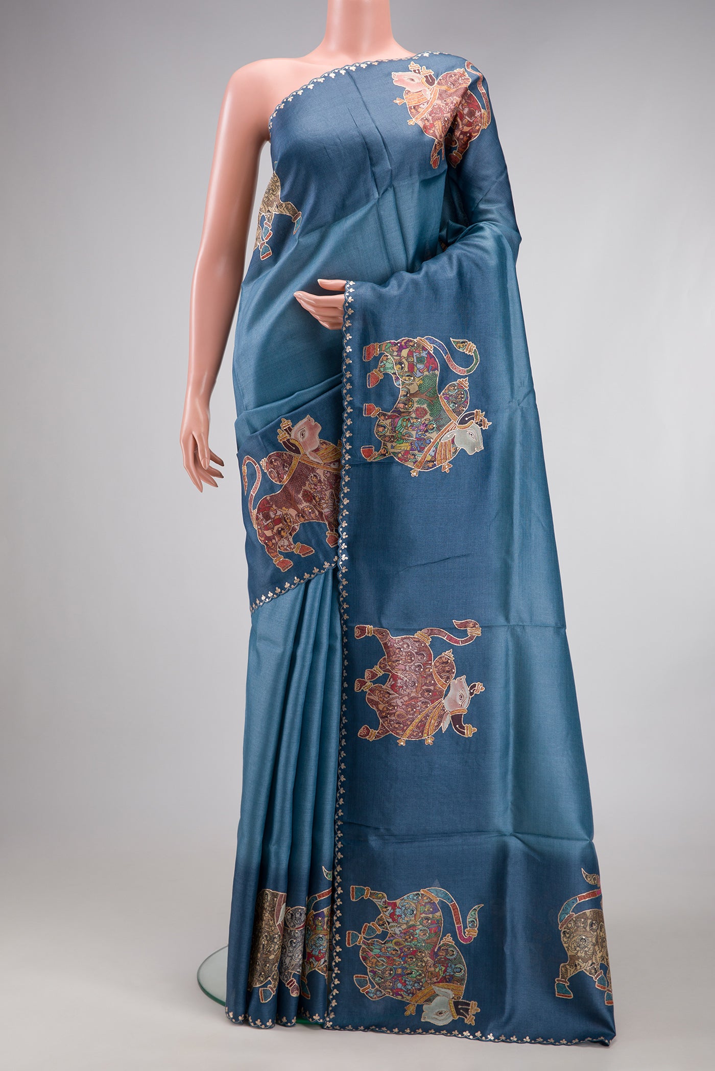Blue Grey Tussar Silk Saree with Plain Body and Fancy Border.  displayed on a mannequin