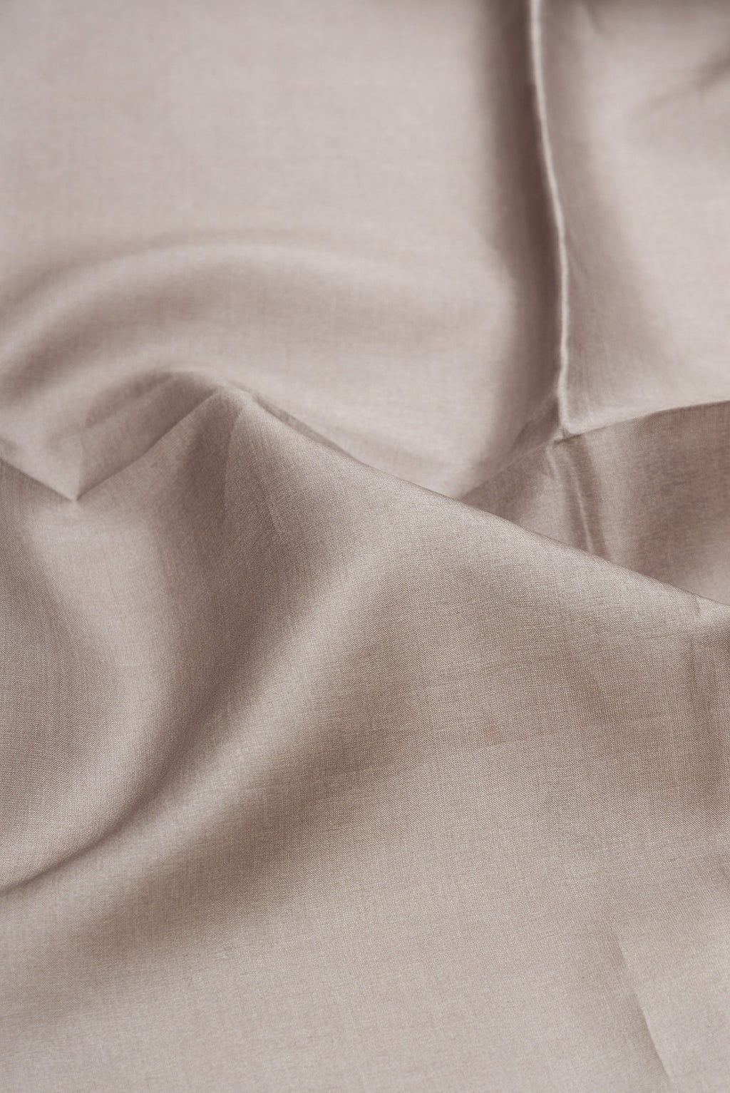Close up of Grey Tussar Silk Saree with Plain Body and Embroidery Border.  displaying folds