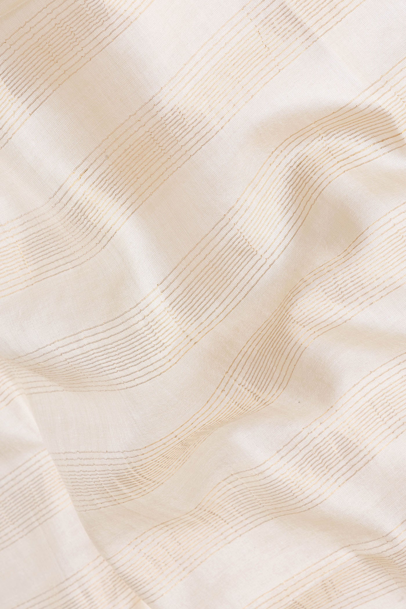 Close up of Beige Tussar Silk Saree with Stripes on the body and Fancy Border.  displaying folds