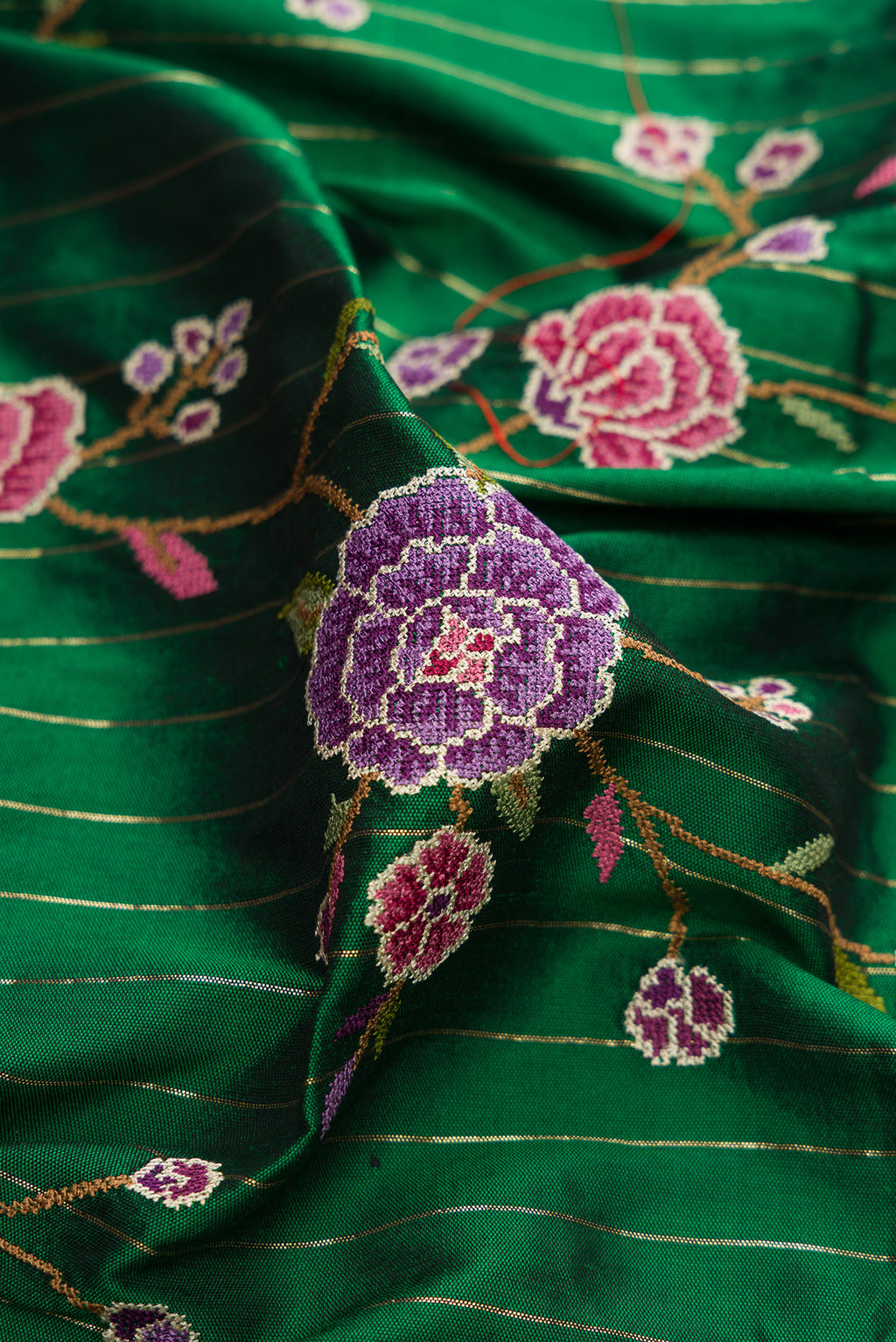 Close up of Green Paithani Silk Saree with Embroidery on the body and Paithani Border.  displaying folds