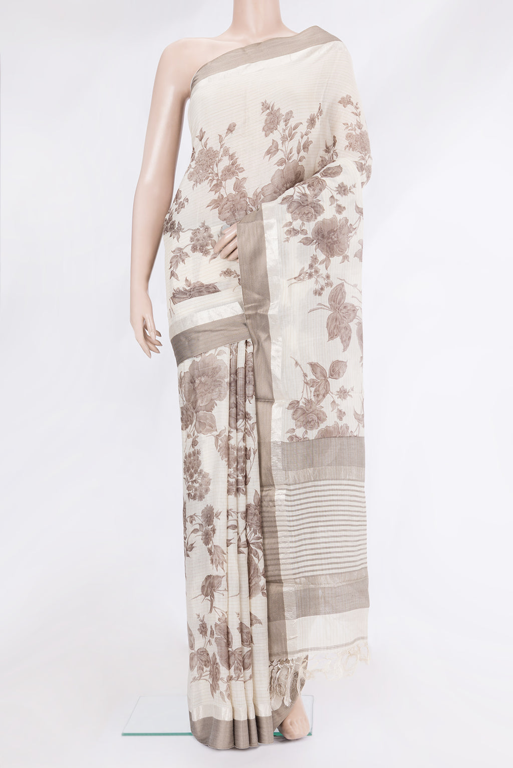 Off White Tussar Silk Saree with Printed design on the body and Zari And Thread Border.  displayed on a mannequin