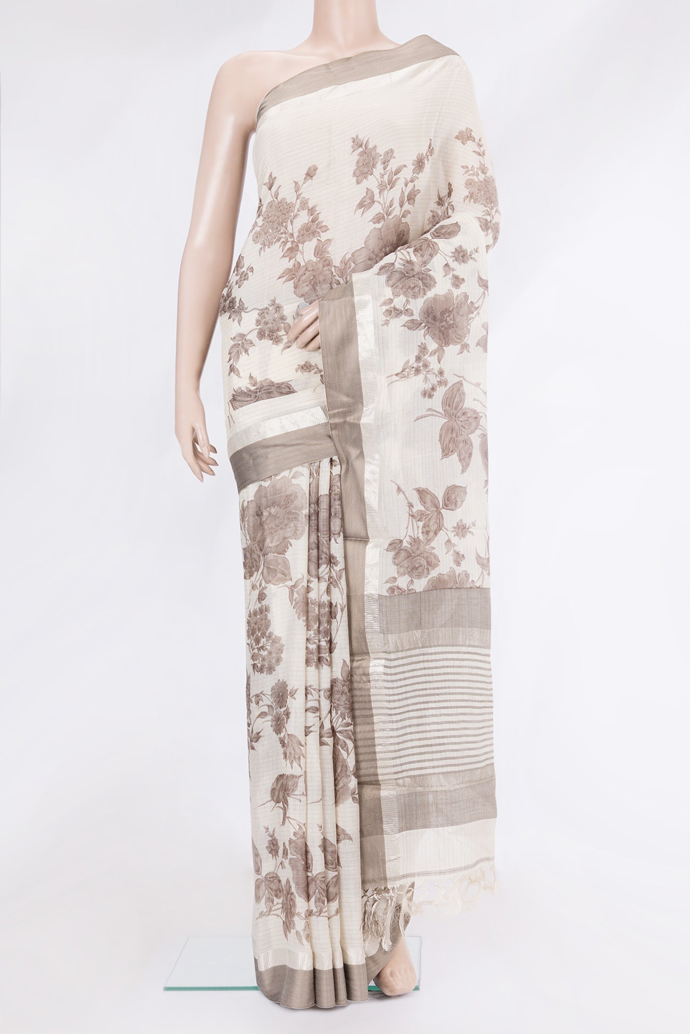 Off White Tussar Silk Saree with Printed design on the body and Zari And Thread Border.  displayed on a mannequin