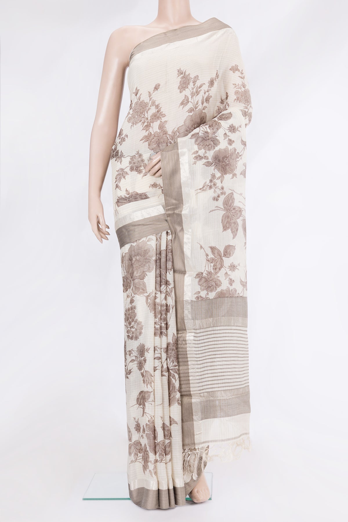 Off White Tussar Silk Saree with Printed design on the body and Zari And Thread Border.  displayed on a mannequin