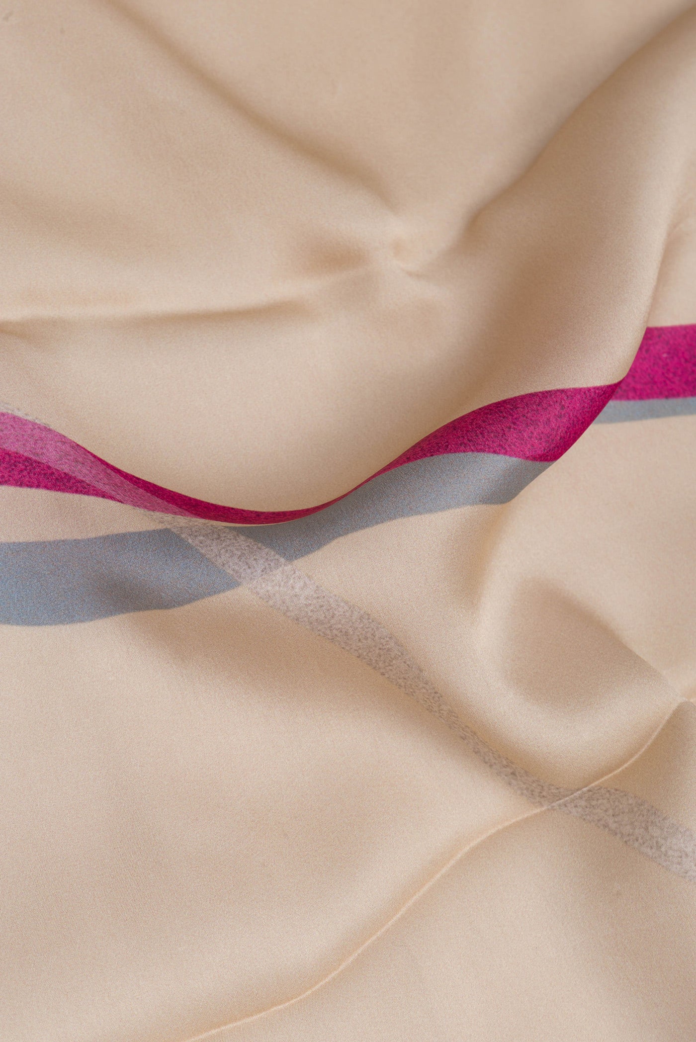 Close up of Beige Crepe Saree with Printed design on the body and Without Border.  displaying folds