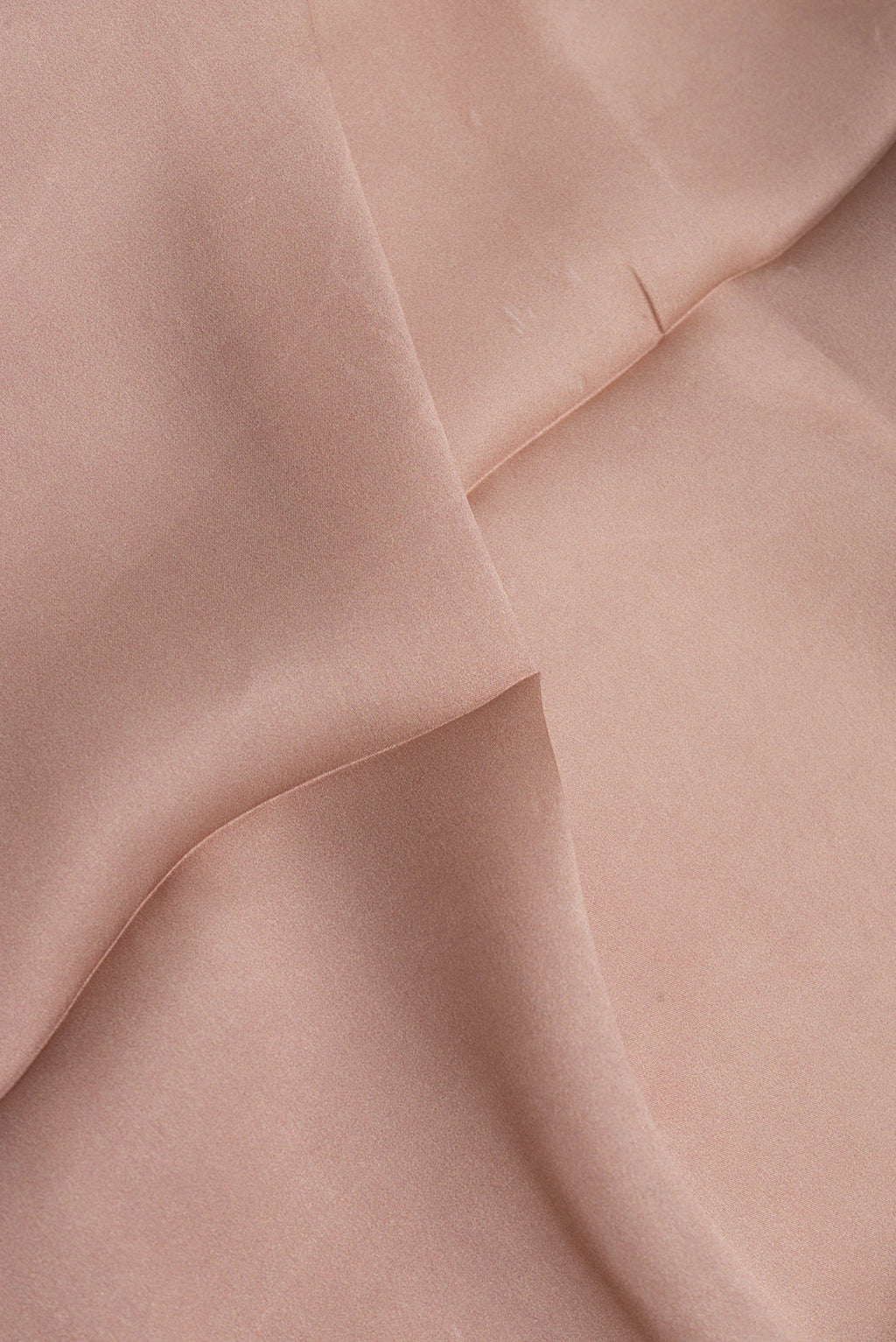 Close up of Brown Crepe Saree with Printed design on the body and Printed Border.  displaying folds