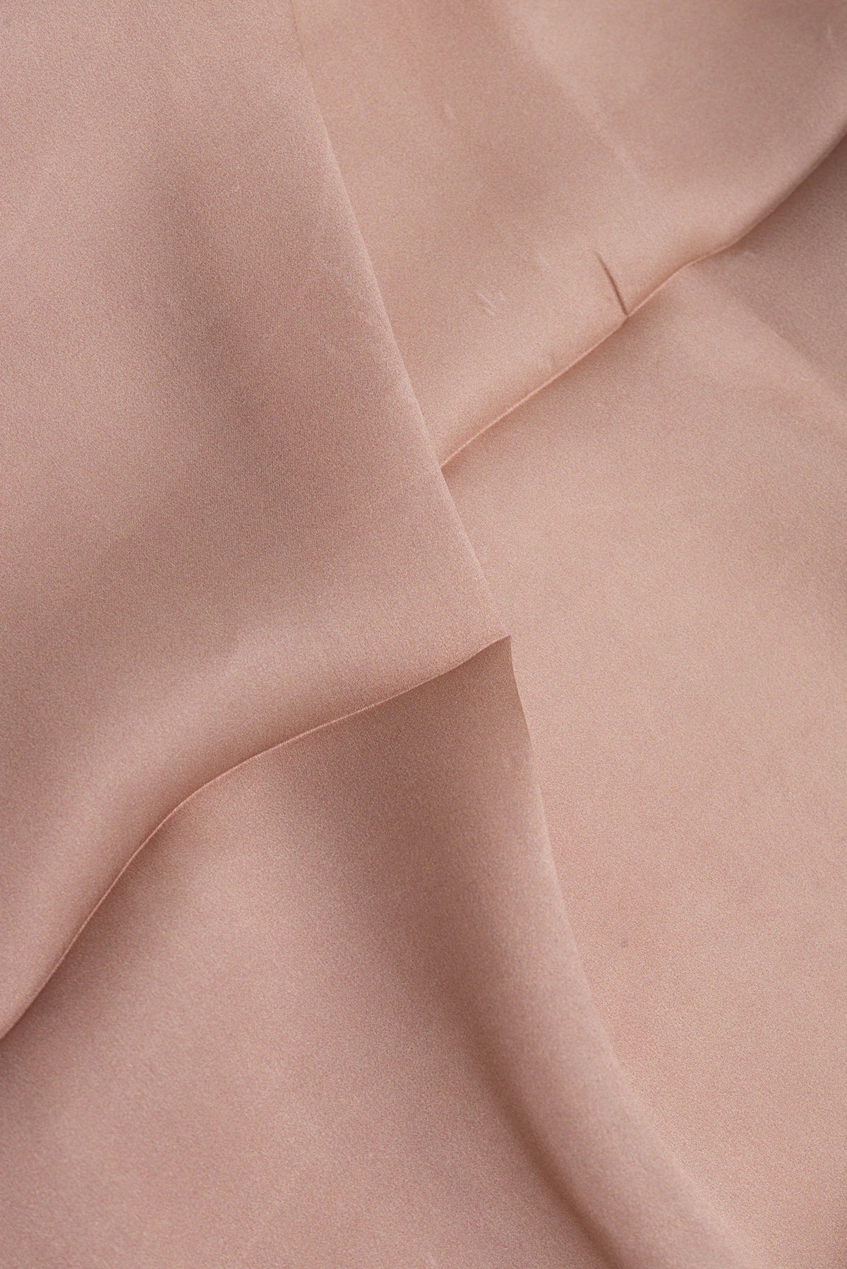 Close up of Brown Crepe Saree with Printed design on the body and Printed Border.  displaying folds