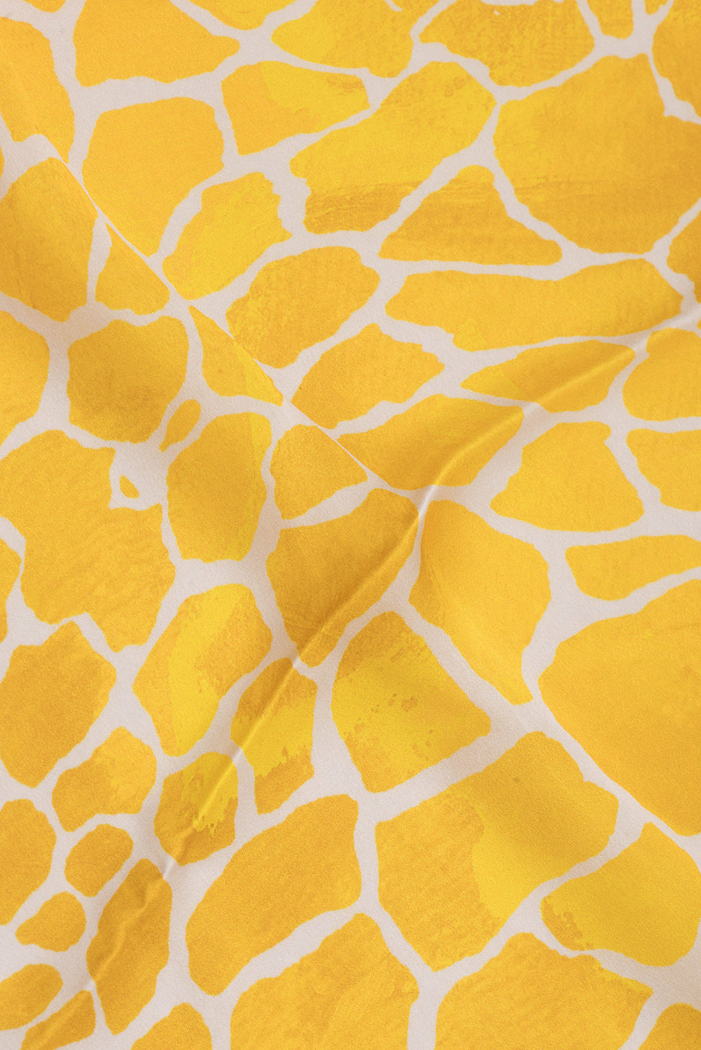Close up of Yellow Crepe Saree with Printed design on the body and Without Border.  displaying folds