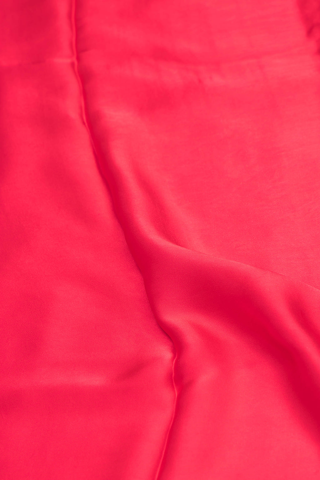 Close up of Red Crepe Saree with Plain Body and Without Border.  displaying folds