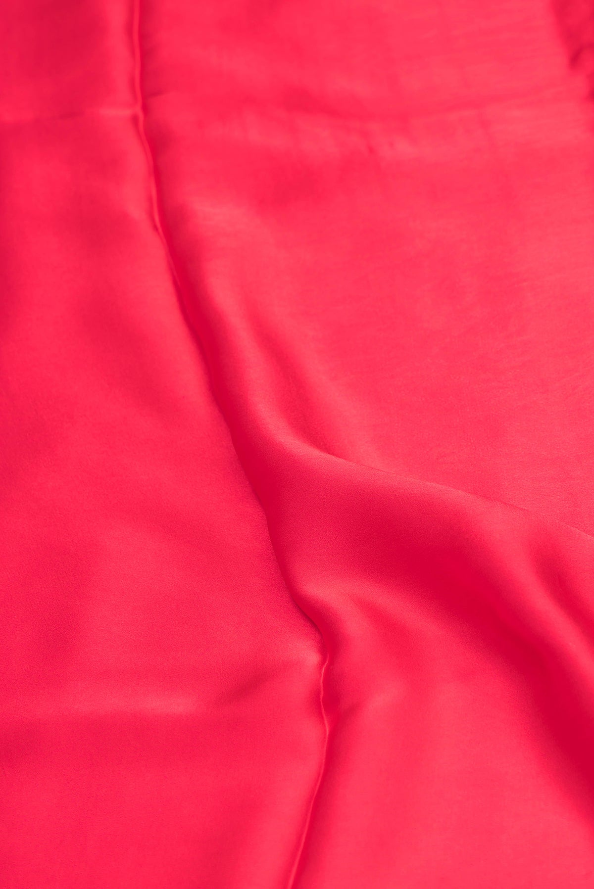Close up of Red Crepe Saree with Plain Body and Without Border.  displaying folds