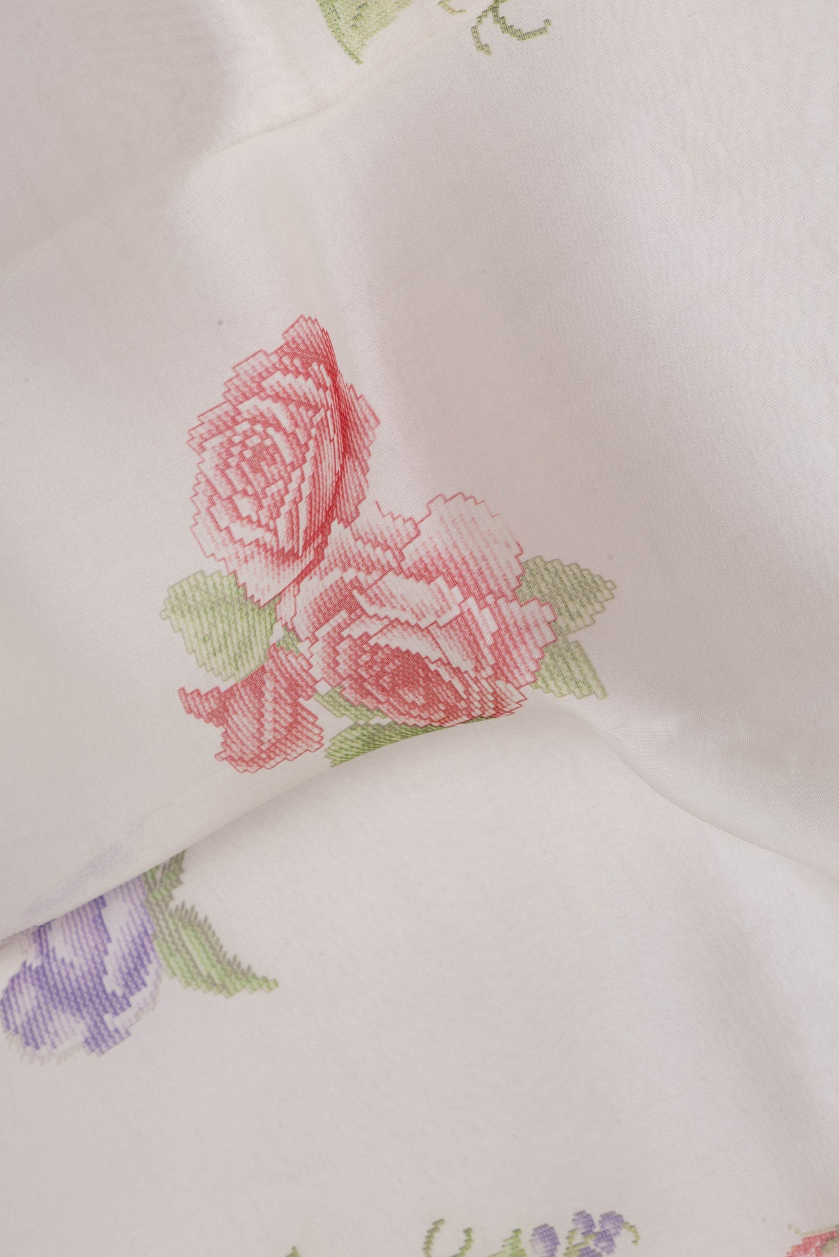 Close up of Cream Organza Silk Saree with Floral Print on the body and Zari Border.  displaying folds