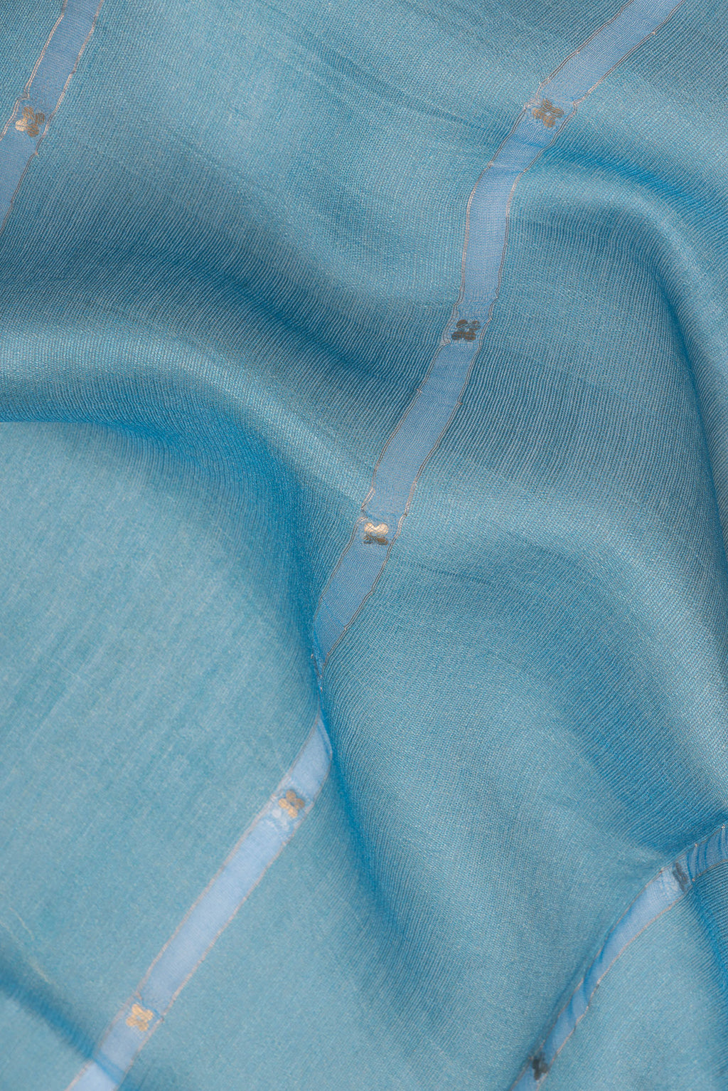 Close up of Pure Silk Sky Blue Dual Tone Tussar Saree with Embroidery on the body and Fancy Border.  displaying folds