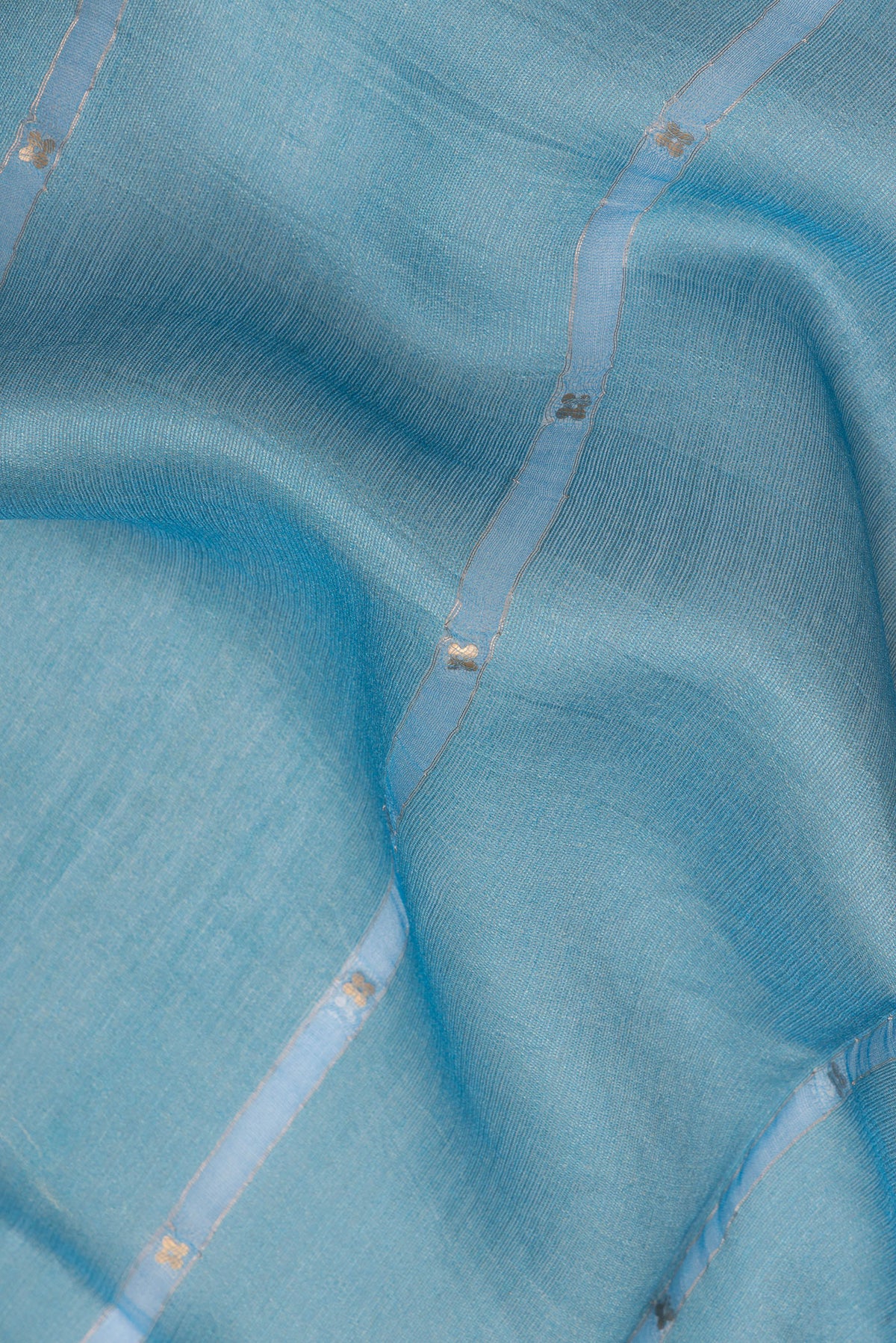 Close up of Pure Silk Sky Blue Dual Tone Tussar Saree with Embroidery on the body and Fancy Border.  displaying folds