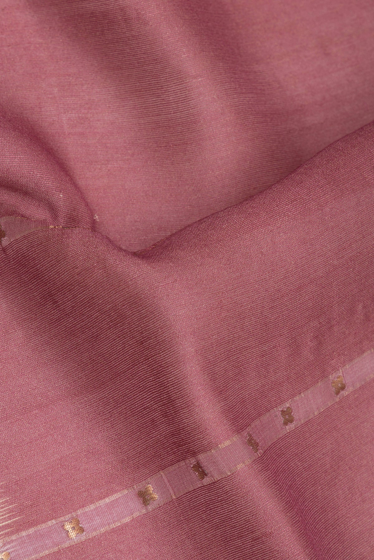 Close up of Pure Silk Coral Tussar Saree with Embroidery on the body and Fancy Border.  displaying folds