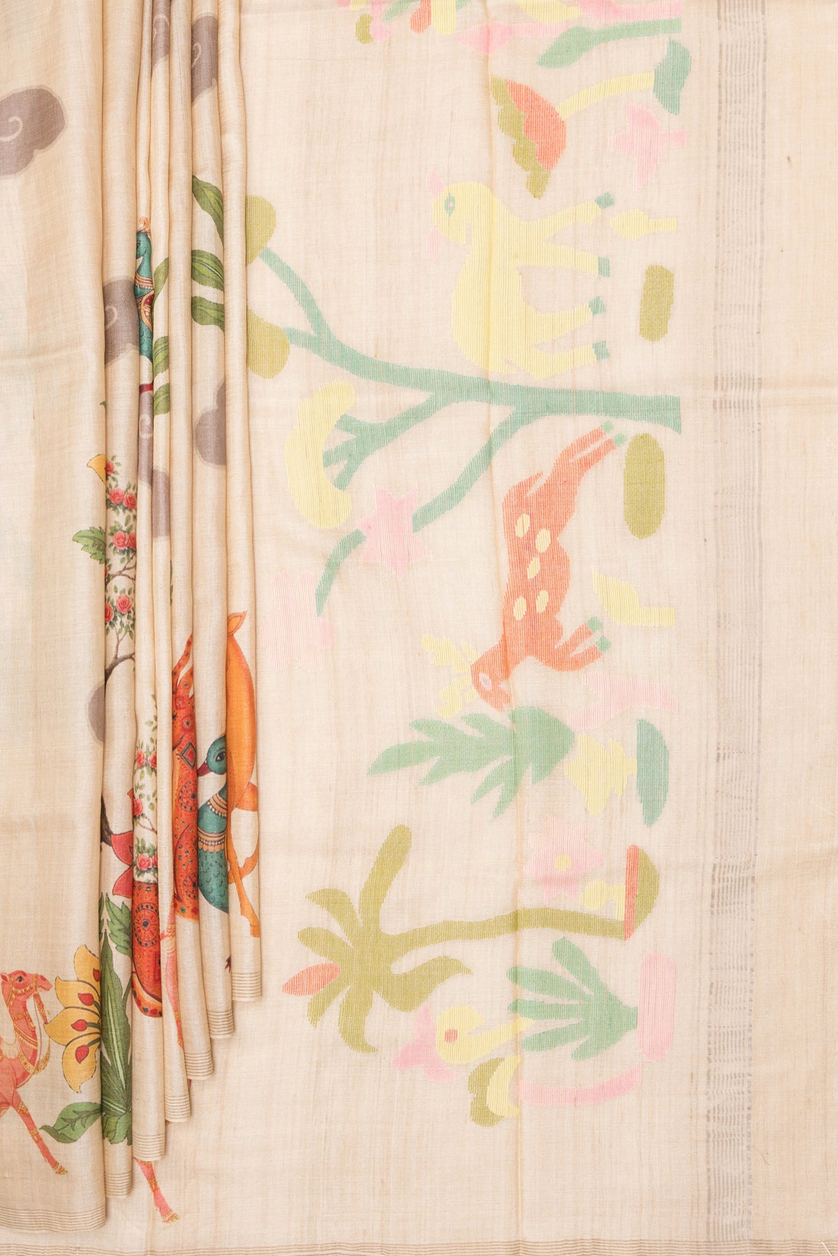 Pleats and pallu of Beige Tussar Saree with Printed design on the body and Zari Border. 