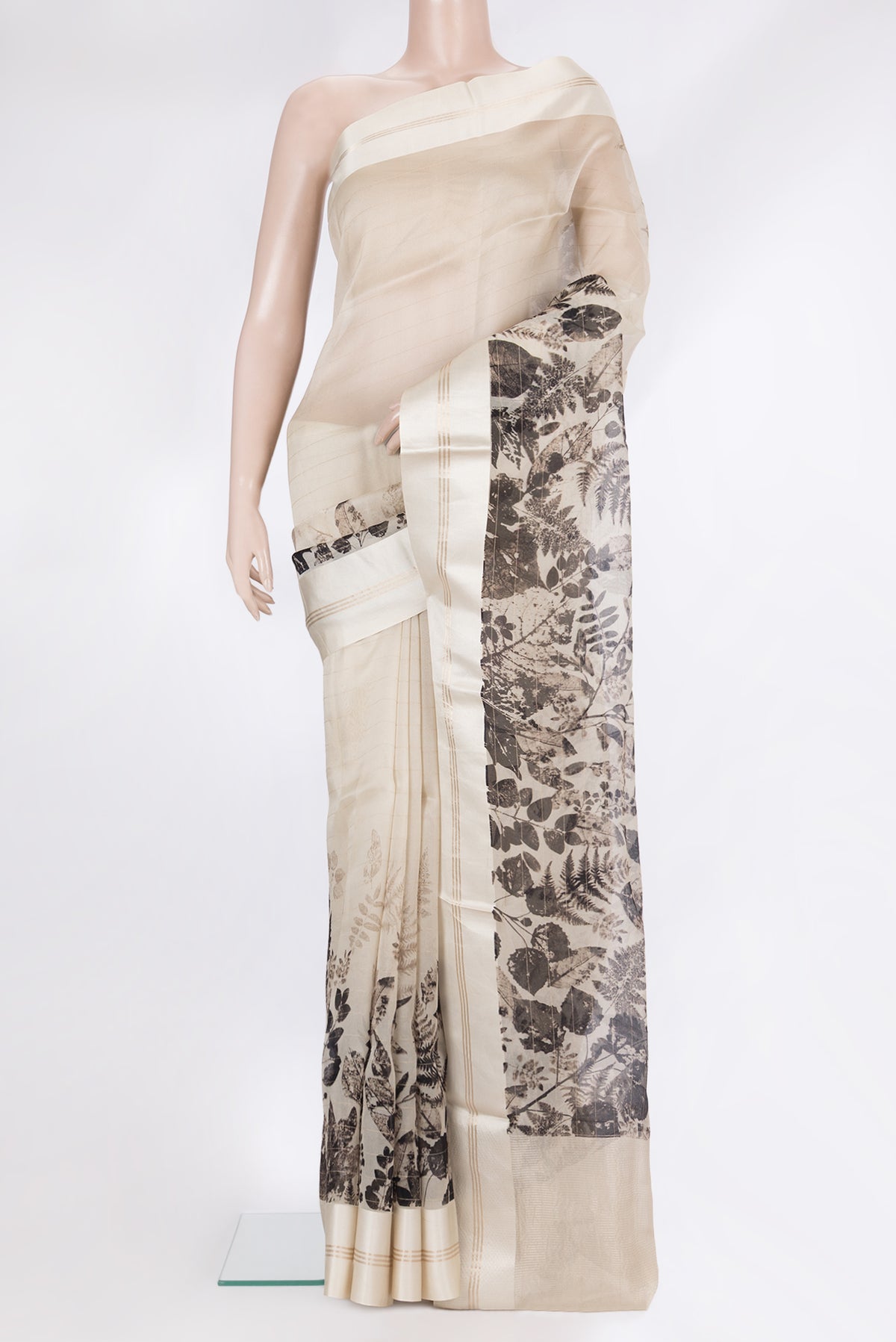 Beige Organza Saree with Printed design on the body and Plain Border.  displayed on a mannequin