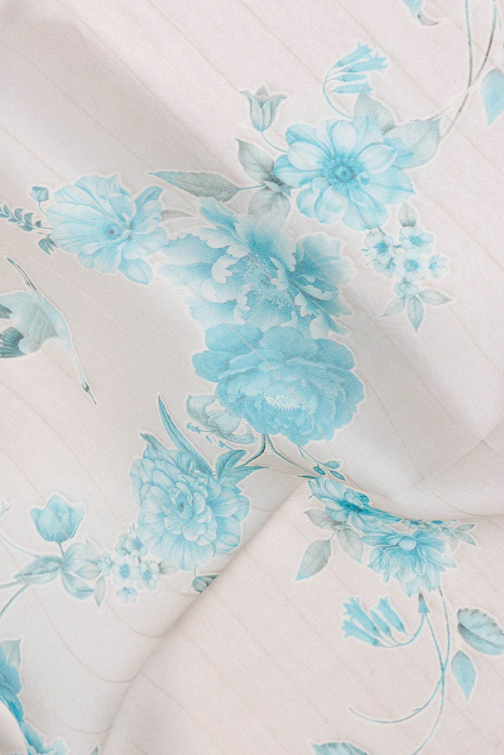 Close up of Cream Organza Silk Saree with Floral Print on the body and Satin Border.  displaying folds