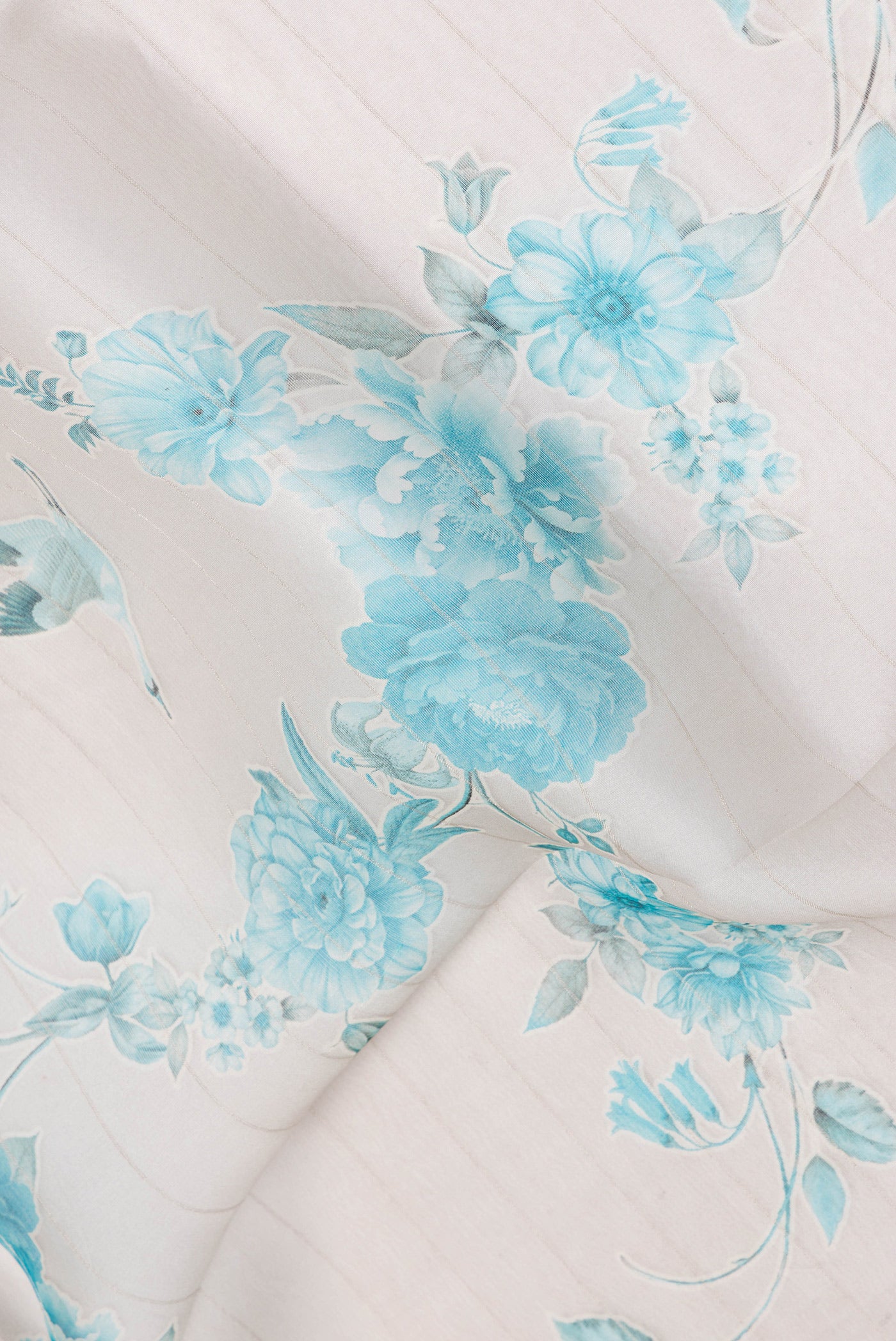 Close up of Cream Organza Silk Saree with Floral Print on the body and Satin Border.  displaying folds