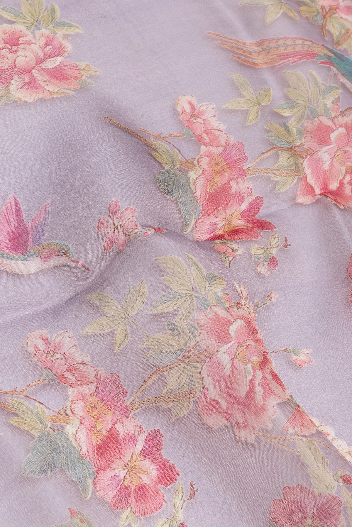 Close up of Lavender Organza Silk Saree with Printed design on the body and Zari Border.  displaying folds