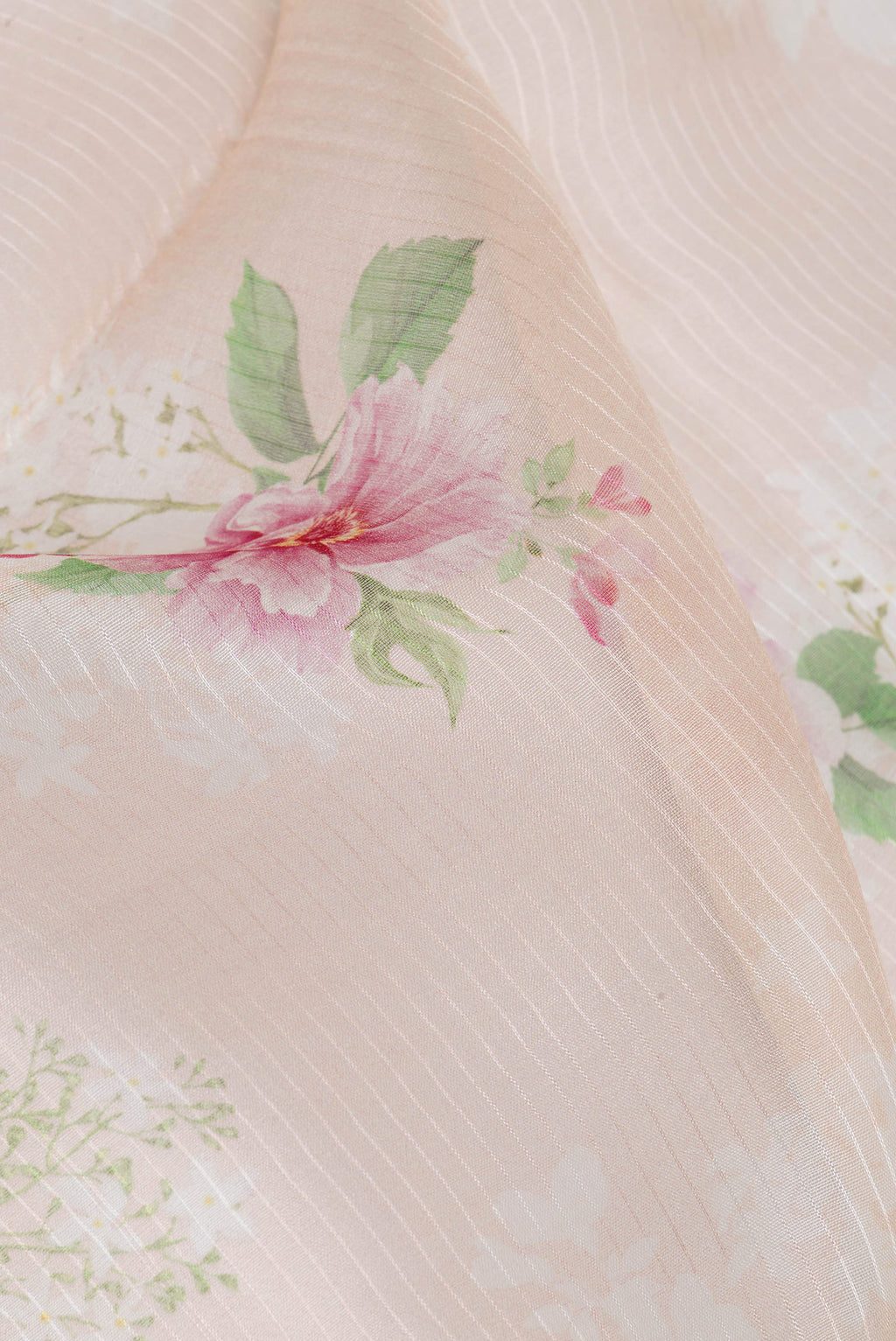Close up of Pure Silk Golden Peach Tussar Saree with Floral Print on the body and Zari Border.  displaying folds