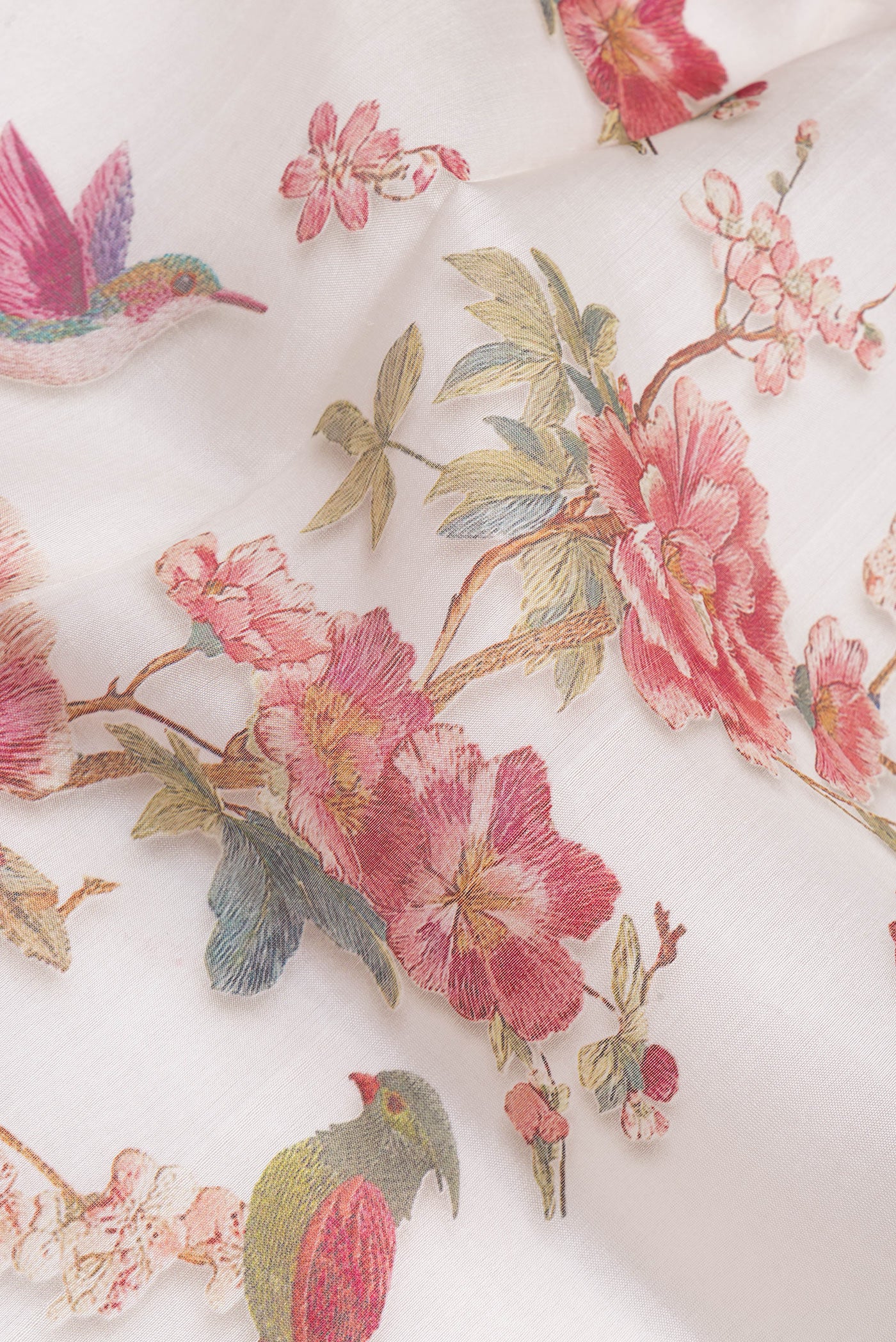 Close up of Off White Organza Silk Saree with Floral Print on the body and Zari Border.  displaying folds