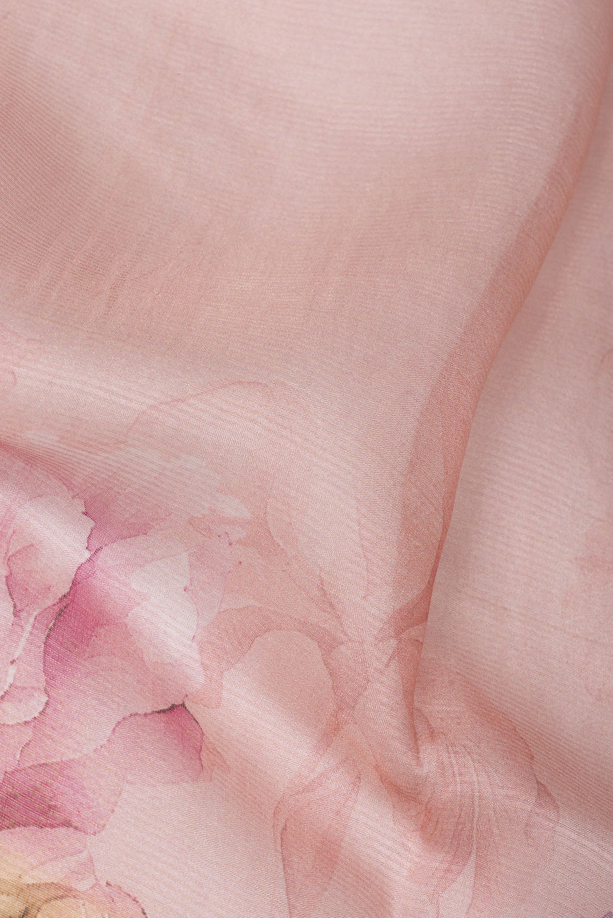 Close up of Golden Peach Tussar Saree with Floral Print on the body and Sequin Border.  displaying folds