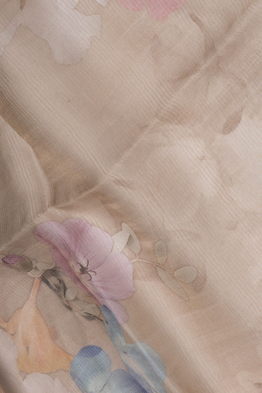 Close up of Beige Tussar Saree with Floral Print on the body and Sequin Border.  displaying folds