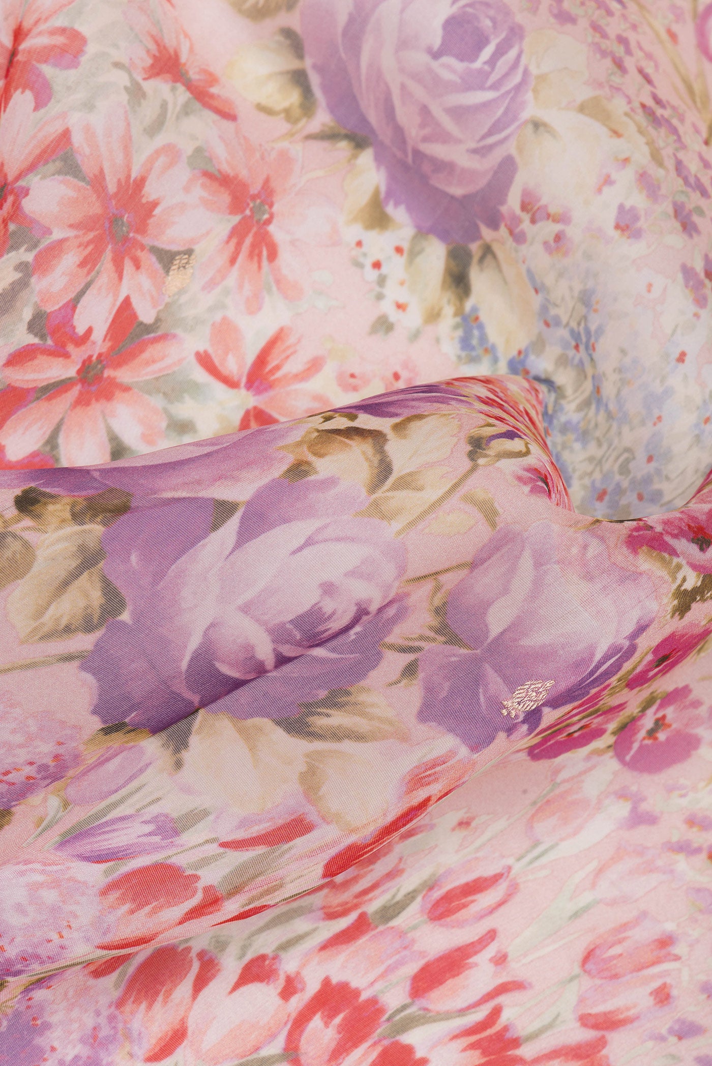 Close up of Golden Peach Organza Silk Saree with Floral Print on the body and Fancy Border.  displaying folds