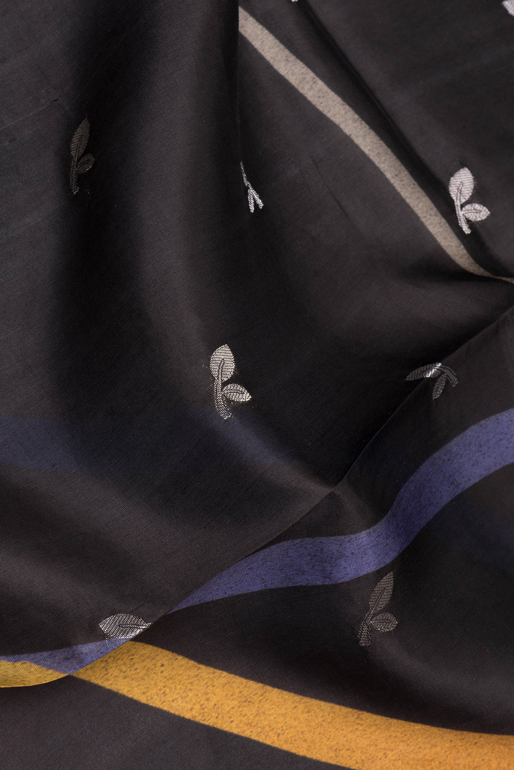 Close up of Pure Silk Black Tussar Saree with Zari Butta on the body and Fancy Border.  displaying folds