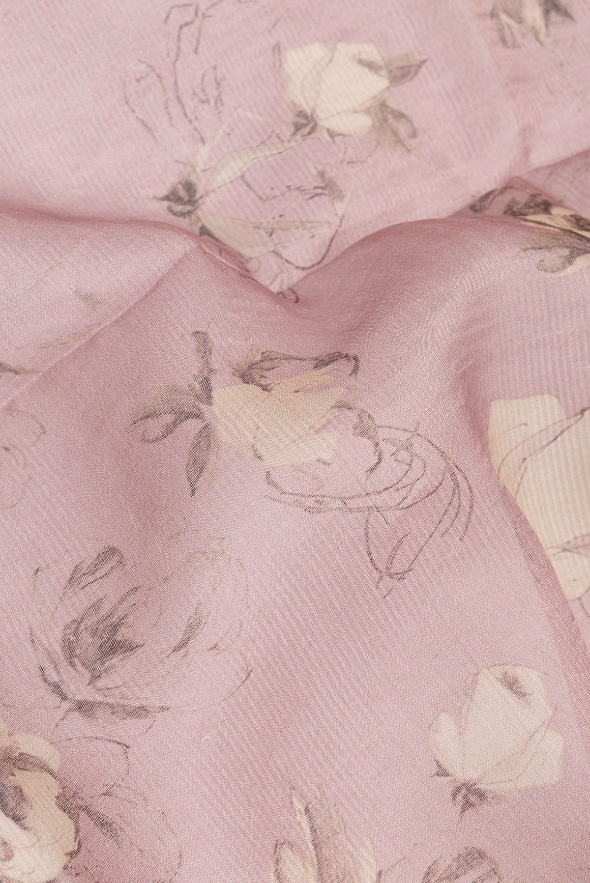 Close up of Rose Gold Tussar Saree with Floral Print on the body and Sequin Border.  displaying folds