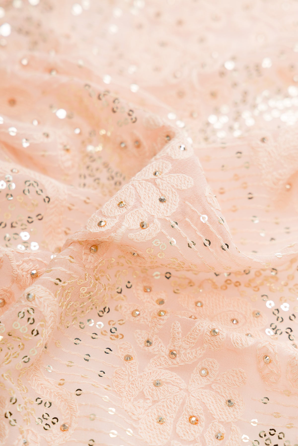 Close up of Peach Dual Tone Mysore Georgette Saree with Embroidered on the body and Sequin Border.  displaying folds