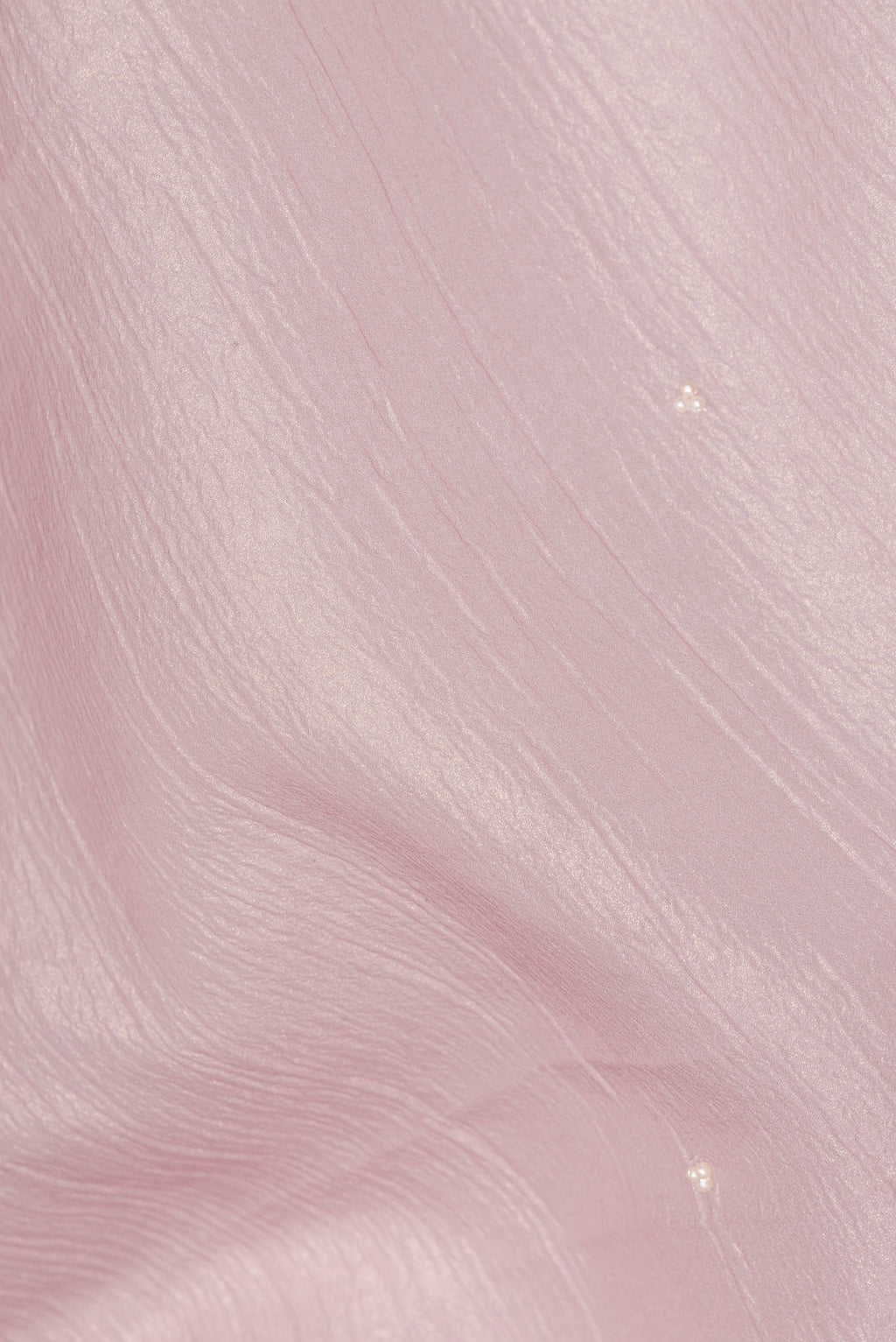 Close up of Rose Gold Dual Tone Organza Saree with Embroidered on the body and Embroidered Border.  displaying folds