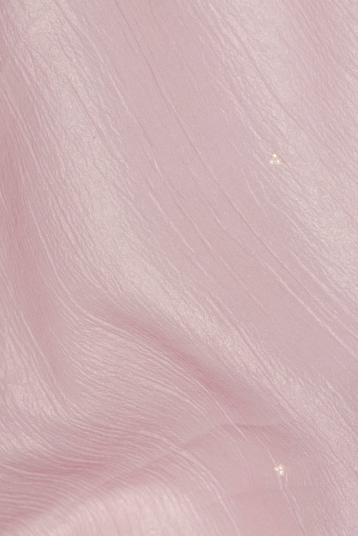 Close up of Rose Gold Dual Tone Organza Saree with Embroidered on the body and Embroidered Border.  displaying folds