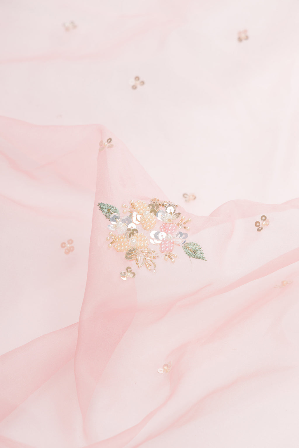 Close up of Pink Organza Saree with Embroidered on the body and Embroidered Border.  displaying folds