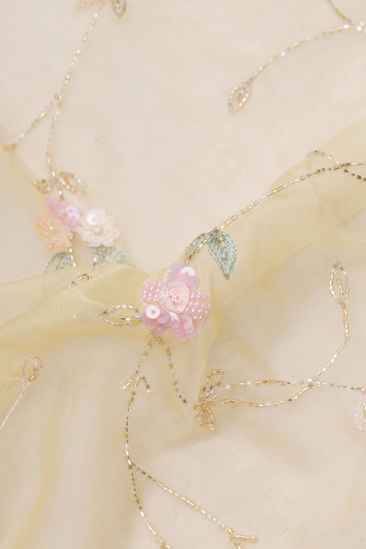 Close up of Pure Silk Lemon Yellow Organza Saree with Embroidered on the body and Embroidered Border.  displaying folds